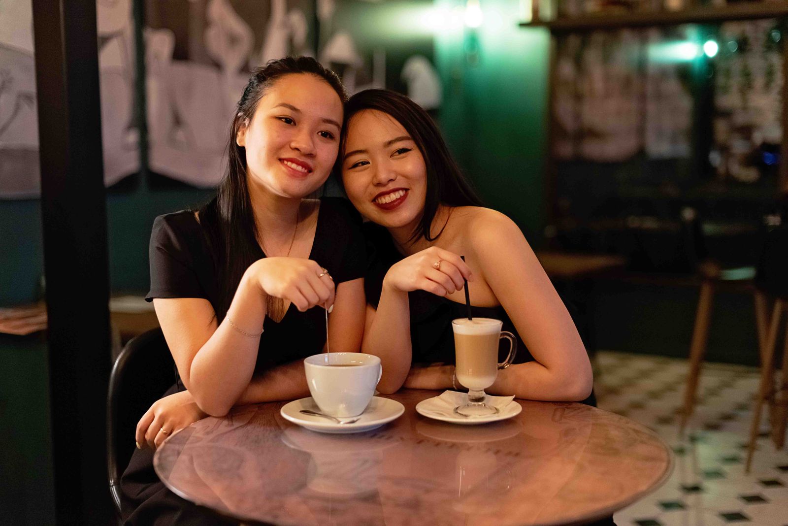 Two friends smiling together over coffee at a cafe