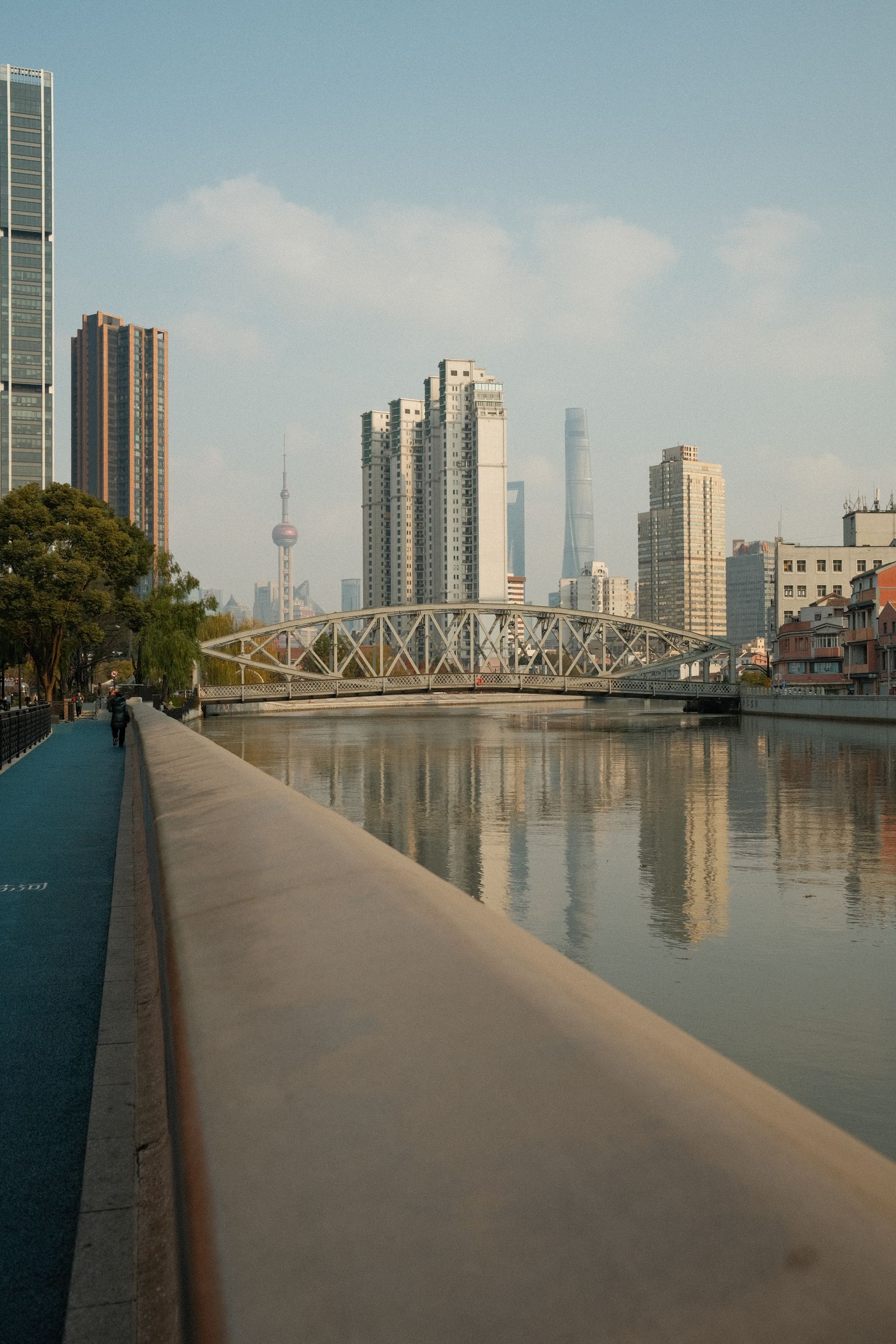 A riverside bridge with the Shanghai skyline in the distance